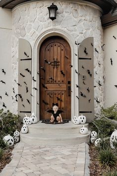 a child sitting in front of a door with bats on it