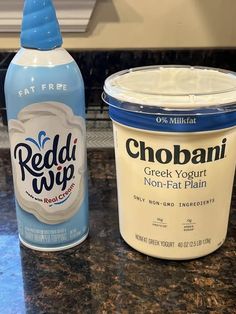 two bottles of yogurt sitting on top of a counter