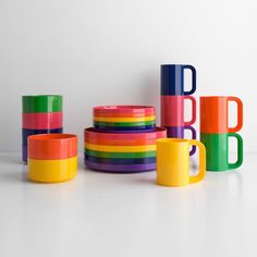 colorful cups and mugs stacked on top of each other in front of the letters b