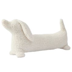 a white stuffed dog laying on top of it's back legs with its head turned to the side