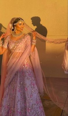 a woman in a purple and pink lehenga