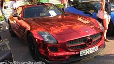 two red sports cars parked next to each other in front of a woman with shopping bags