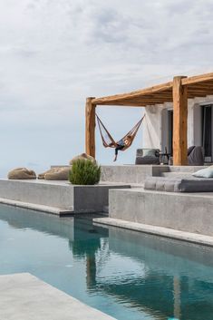 a pool with a hammock hanging from the ceiling next to an outdoor lounge area