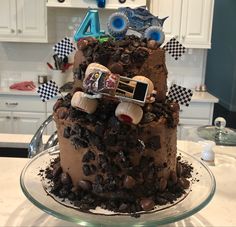 a birthday cake made to look like a monster truck on top of dirt and rocks