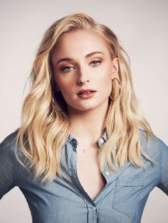 a woman with long blonde hair and blue shirt posing for a magazine cover photo in front of a white background