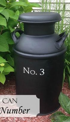 a black urn sitting next to a bush with the words no 3 on it