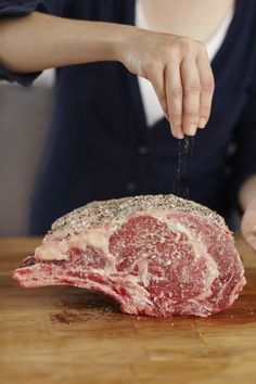 a person is cutting up some meat on a wooden table