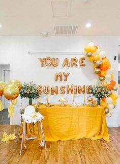 a room with balloons and decorations on the wall, along with a sign that says you are my sunshine shine