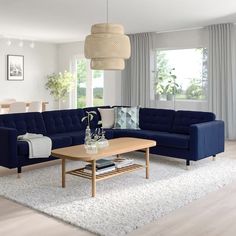 a modern living room with blue couches and white rugs on the hardwood floor