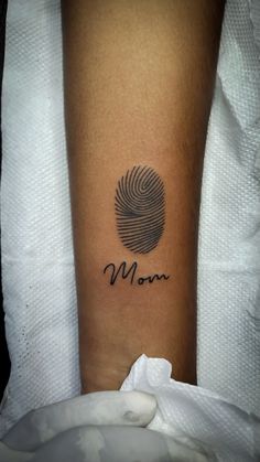 a woman's arm with a finger print on it and the word mom written in cursive font