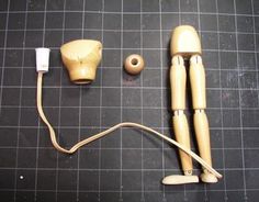 two wooden dolls connected to an electrical cord