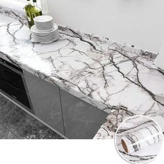 a marble counter top in a kitchen with plates and wine bottles on the countertop