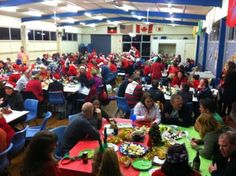 a large group of people sitting at tables eating food