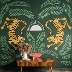 a green wall with yellow and black tiger designs on it, next to a coffee table