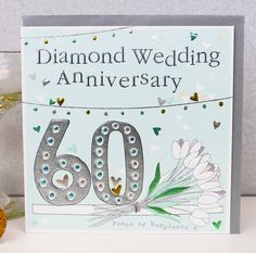 a diamond wedding anniversary card with the number 60 on it and flowers in vases