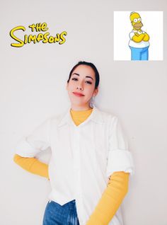 a woman with her hands on her hips posing in front of a white wall and the simpsons logo