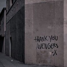 graffiti written on the side of a building reads thank you avengerss and is next to a fire hydrant