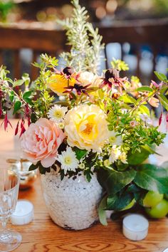 a vase filled with flowers sitting on top of a wooden table