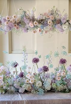 a table topped with lots of flowers and greenery