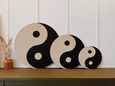 three black and white yin - yang signs sitting on top of a table