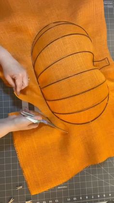 someone is cutting out a piece of fabric with scissors