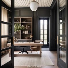 a home office with black walls and wood flooring, along with an open door leading to the living room