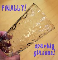 a person is holding a glass in their hand with the words finally sparkly glasses on it