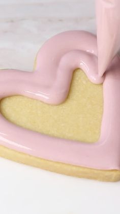 a cookie shaped like a heart with pink icing