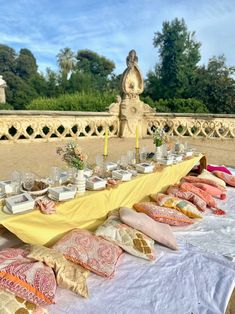 a table with many pillows and plates on it