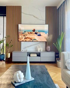 a living room filled with furniture and a flat screen tv on top of a wooden table