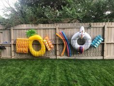 a fence that has some fake objects on it in the shape of an oar and life preservers