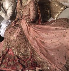 a man and woman sitting on top of a couch next to each other in wedding outfits