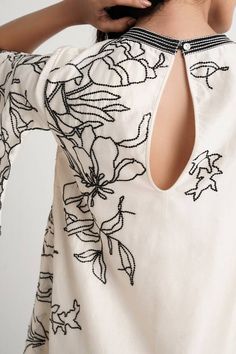 Natural vanilla short dress with floral cutwork embroidery and asymmetric sleeves. - Aza Fashions Elegant Summer Tops With Geometric Embroidery, Elegant Summer Embroidered Dress With Embroidered Neckline, Elegant Embroidered Dress With Neckline Detail For Summer, Elegant Summer Dress With Embroidered Neckline, Elegant Tunic Embroidered Dress With Floral Details, Elegant Floral Embroidered Tunic Dress, Elegant Summer Tunic Embroidered Dress, Elegant Tunic Dress With Intricate Embroidery, Elegant Tunic Dress With Embroidered Neckline