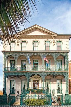 a large white house with green trim and balconies