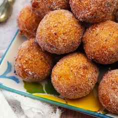 some sugared doughnuts are on a plate