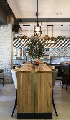 a wooden table sitting in the middle of a room with chairs and tables around it