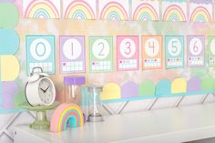 there is a clock on the wall next to a rainbow themed calendar and other items