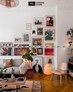 a living room filled with lots of pictures on the wall and furniture in front of it