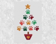 a cross stitch christmas tree with paw prints