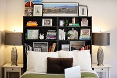 a laptop computer sitting on top of a bed next to a book shelf filled with books