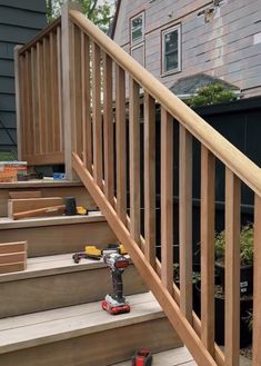 a set of stairs leading up to a house with wood handrails and tools on the steps