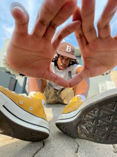 a person sitting on the ground with their hands in front of them, making a heart shape