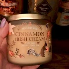 a hand holding a jar of cinnamon irish cream