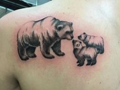 a bear and two cubs tattoo on the back of a man's left shoulder