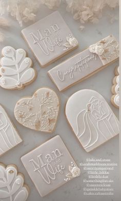 some cookies that have been decorated with wedding decorations and words on them in the shape of hearts