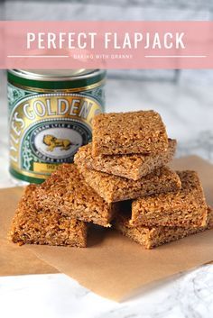 three pieces of granola are stacked on top of each other with a jar of glaze in the background