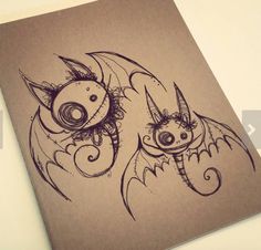 a drawing of two bats on top of a piece of brown paper with black ink