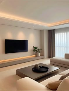 a living room with couches and a large flat screen tv mounted on the wall