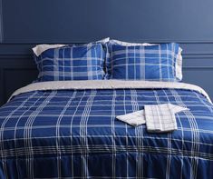 a bed with blue and white plaid sheets