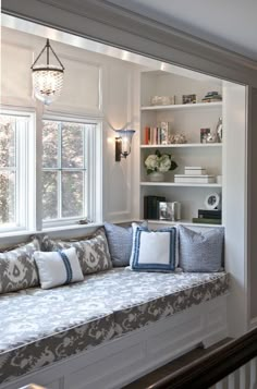 a living room filled with lots of furniture and bookshelves next to a window